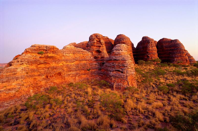 Image of red rock formation in a desert landscape at sunset